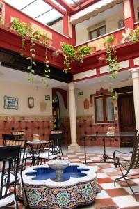 patio ze stołami, krzesłami i fontanną w obiekcie Apartamentos Medina Qurtuba w Kordobie