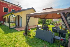 a patio with an umbrella and chairs in a yard at Il Vecchio Noce in Brugnato