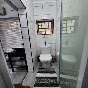 a small bathroom with a toilet and a sink at Groenewald's Haven in Nelspruit