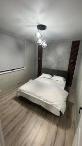 - une chambre avec un grand lit blanc et un projecteur dans l'établissement Батыс, à Aqtöbe