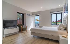a bedroom with a large bed and a flat screen tv at Estrella Beach APT Jardim do Mar in Jardim do Mar