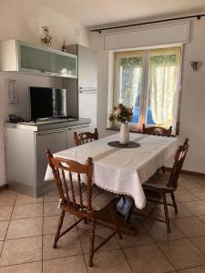 a dining room with a table and a kitchen with a television at Appartamento Margherita in Transacqua