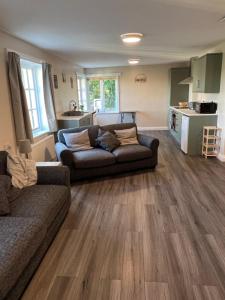 a living room with two couches and a kitchen at The annex in Bradninch