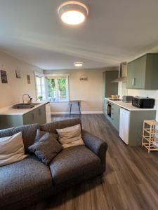 a living room with a couch and a kitchen at The annex in Bradninch