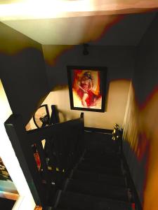 una escalera con una pintura en la pared en Love-Room Chic&Glam', en Saint-Vincent-de-Paul