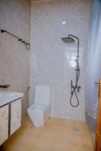 Mama's Favourite Apartments في كيغالي: حمام مع مرحاض أبيض ودش