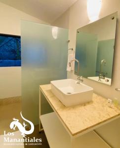 y baño con lavabo blanco y espejo. en Balneario Natural Los Manantiales, en Coaxitlan