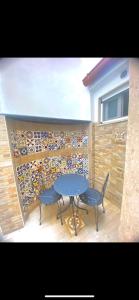 une table et deux chaises devant un mur dans l'établissement San Nicola Suite & mini apartment, à Sorrente