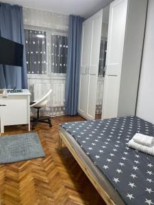 a bedroom with a bed and a desk and a window at Lux Apartment Vivo Mall in Baia Mare