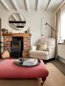 a living room with a fireplace and a mirror at Charming 3 bedroom house in Woodbridge area in Grundisburgh