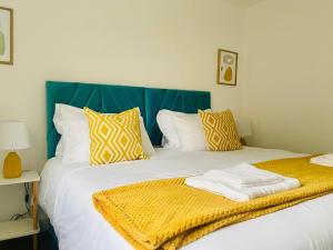 Un dormitorio con una cama con una manta amarilla. en Norfolk House, 