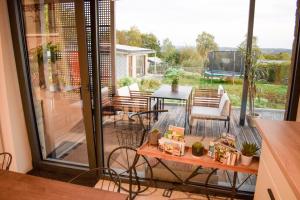 a room with a balcony with a table and chairs at Le Terrier Ovifat - Appartement entier Familial - Sauna & Massage in Ovifat