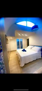 - une chambre avec un grand lit blanc et une lumière bleue dans l'établissement San Nicola Suite & mini apartment, à Sorrente