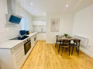 uma cozinha com uma mesa e uma sala de jantar em Norfolk House 