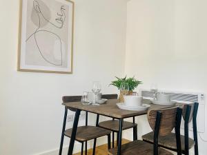 a dining room table with chairs and a table with a picture at Norfolk House 