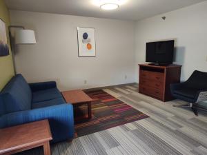 ein Wohnzimmer mit einem blauen Sofa und einem TV in der Unterkunft Holiday Inn Express Hotel & Suites Sioux Falls At Empire Mall, an IHG Hotel in Sioux Falls