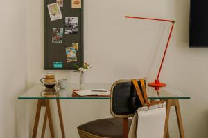 escritorio con mesa de cristal con silla y lámpara en Chambers powered by Sonder, en Nueva York