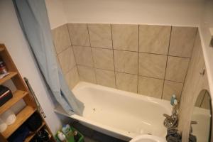 y baño con bañera blanca y lavamanos. en Appartement spacieux Lille en Lille