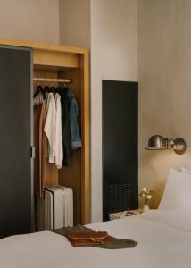 a bedroom with a closet and a bed and a suitcase at Chambers powered by Sonder in New York