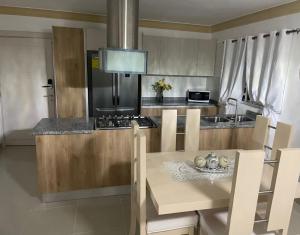 a kitchen with a table and a stove top oven at Lujoso jacuzzi privado mi cell 347-864 -3082 in San Francisco de Macorís