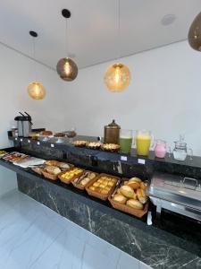 ein Buffet mit vielen verschiedenen Arten von Donuts und Getränken in der Unterkunft Hotel Pousada Colliseu in Aparecida