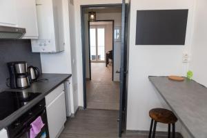 eine Küche mit einer Theke und eine Tür zu einem Flur in der Unterkunft A spacious nest for an unforgettable holiday in Perpignan