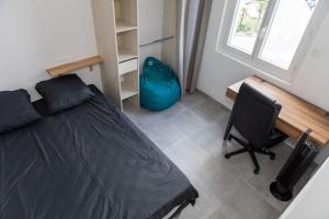 Schlafzimmer mit einem Bett, einem Schreibtisch und einem Stuhl in der Unterkunft A spacious nest for an unforgettable holiday in Perpignan