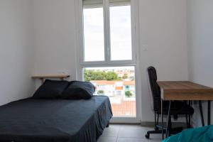 Schlafzimmer mit einem Bett, einem Schreibtisch und einem Fenster in der Unterkunft A spacious nest for an unforgettable holiday in Perpignan