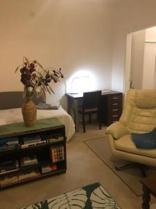 een woonkamer met een bank, een stoel en een bureau bij Renovated two room apt in Rauma centre with amenities in Rauma