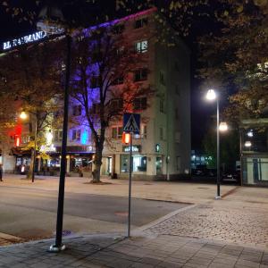 a city street at night with a building and a traffic light at Renovated two room apt in Rauma centre with amenities in Rauma