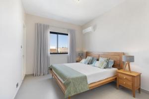 1 dormitorio con cama y ventana grande en One Bay Penthouse en Grand Baie