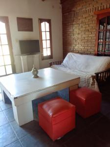 Habitación con escritorio y cama con taburetes rojos. en Alquiler temporario Santo Tome en Santo Tomé