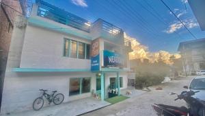 a white building with two bikes parked outside of it at Hotel Mountain Meadows in Manāli