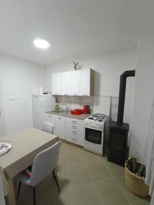 a kitchen with a stove and a table and a stove top oven at Luce in Kijevo