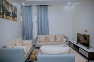 Mama's Favourite Apartments في كيغالي: غرفة معيشة مع أريكتين وتلفزيون