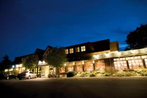 un bâtiment avec des voitures garées à l'extérieur le soir dans l'établissement Hotel Zwei Linden - links der Elbe - Niedersachsen, à Balje