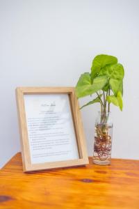 a picture frame with a plant in a vase on a table at The Yellow Door Guesthouse in East London