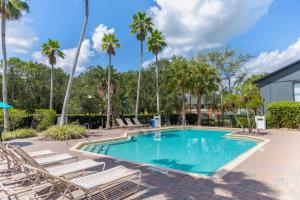 a swimming pool with lounge chairs and palm trees at Legacy Vacation Resorts - Disney and Lake Buena Vista in Orlando