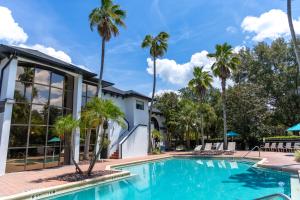a swimming pool with palm trees in front of a building at Legacy Vacation Resorts - Disney and Lake Buena Vista in Orlando