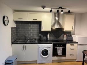 a kitchen with a sink and a washing machine at Stonebarn Lane in Halton