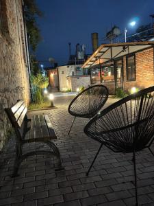 two benches sitting next to a building at night at Hotel and Hostel Ticiani 15 in Kutaisi