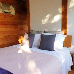 - un lit avec des draps et des oreillers blancs dans une chambre dans l'établissement Rouet Nature, à Tréban