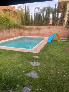 een klein zwembad met een glijbaan in het gras bij Villa Soleil 4 chambres in Marrakesh
