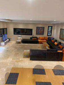 een grote woonkamer met banken en een televisie bij Villa Soleil 4 chambres in Marrakesh
