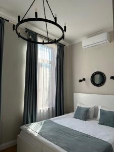 a bedroom with a bed with a chandelier above it at Hotel and Hostel Ticiani 15 in Kutaisi