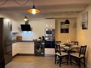 Una cocina con una mesa y un comedor. en Apartamento a 2 minutos de la playa, en Málaga