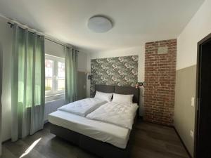 ein Schlafzimmer mit einem Bett und einer Ziegelwand in der Unterkunft Haus 15 Apartments in Bielefeld