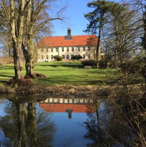 a large house with a reflection in a pond at An der Aue in Klütz