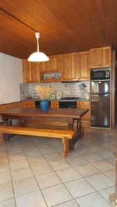 a kitchen with a table and a refrigerator at Chez Bernard & Chantal in Peisey-Nancroix