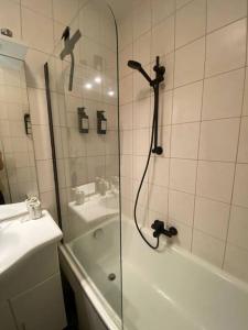 ein Badezimmer mit einer Dusche, einer Badewanne und einem Waschbecken in der Unterkunft Schöne Wohnung in zentraler Lage in Klagenfurt am Wörthersee